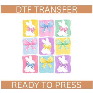 May include: DTF TRANSFER and READY TO PRESS text above and below a grid of nine colorful squares. Each square features a white bunny with a bow, in various colors, on a pastel background.