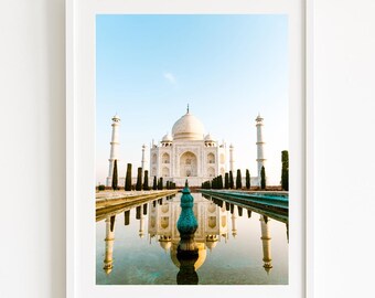 May include: A white marble building with a reflecting pool in front of it. The building has a dome and minarets. The reflection of the building is visible in the water.