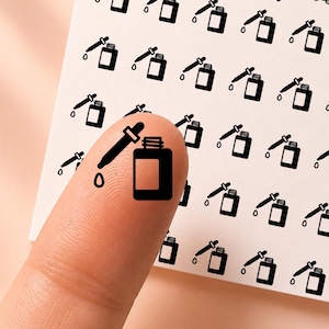 May include: A white square sticker sheet featuring a repeating pattern of small black dropper bottle icons. The text "honeyed sunflower" and "CL107" are printed at the top. One individual dropper bottle sticker is applied to a fingertip.