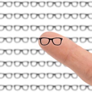 May include: A finger with a black-framed glasses illustration, set against a backdrop of blurred glasses outlines. The image suggests a focus on vision or eyewear, with a clear emphasis on the featured glasses.