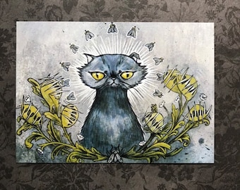 Può includere: Un gatto blu con occhi gialli seduto in un campo di fiori gialli con spine. Il gatto ha un'espressione scontrosa ed è circondato da piccole mosche.