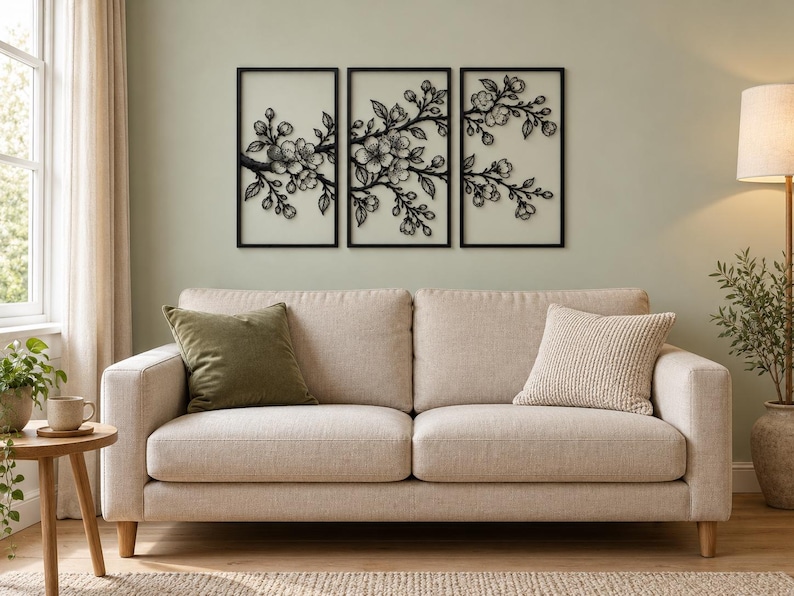 May include: A set of three rectangular black metal wall art panels featuring a detailed cutout design of flowering cherry blossom branches. Each panel is framed in black and displays a continuous botanical motif of buds and blossoms.