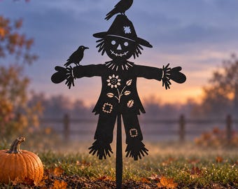 May include: A black metal silhouette of a scarecrow with a pointed hat, a stitched face, and frayed edges on the sleeves and pant legs. The design features a sunflower cutout on the chest, two crows perched on the shoulders and hat, and a stake.