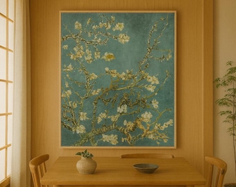 May include: A framed print of a painting featuring a blossoming almond tree branch against a teal background. The artwork is displayed above a wooden dining table with two chairs. A small vase and bowl are on the table.