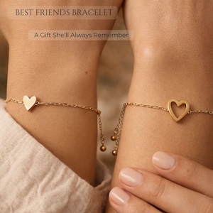 May include: Two gold-colored friendship bracelets, each featuring a heart design. One heart is solid, the other is an open heart. The bracelets are on a delicate chain with dangling beads. Text reads "BEST FRIENDS BRACELET" and "A Gift She'll Always Remember."