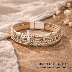 Può includere: Bracciale in pelle beige con un ciondolo a forma di croce argentata con la scritta "BLESSED". Il bracciale ha una chiusura magnetica, strass e piccole perline d'argento. Il testo "BOHO CROSS BRACELET" e "MEANINGFUL FAITH JEWELRY" sono in basso.
