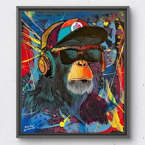 Puede incluir: Obra de arte enmarcada que representa un chimpancé con gafas de sol, gorra y auriculares. El retrato del chimpancé se sitúa sobre un fondo abstracto vibrante con salpicaduras de pintura roja, azul y amarilla.