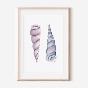 May include: Watercolor print of two spiral seashells in shades of lavender and blue-grey. The artwork is framed in a light wood frame, perfect for coastal or beach-themed decor. The shells are painted with soft watercolor techniques.