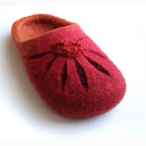 May include: Red felt slippers with a flower design cut out of the fabric.