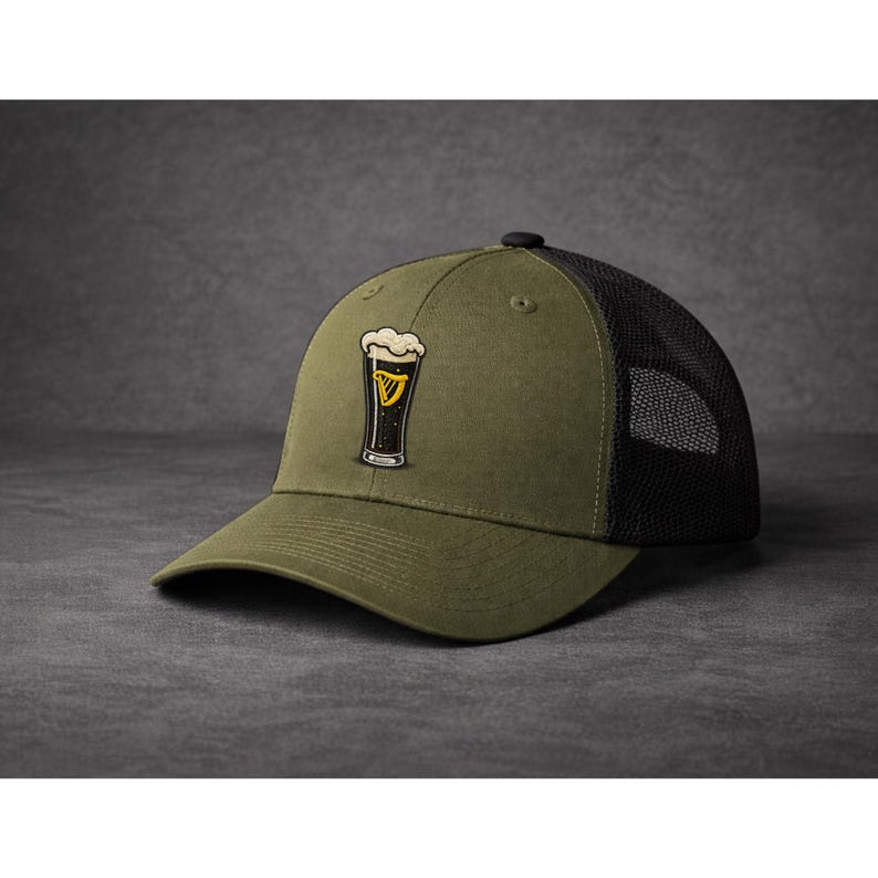 May include: Olive green baseball cap with a black mesh back. The cap features an embroidered design of a pint of stout with a foamy head and a gold harp emblem.