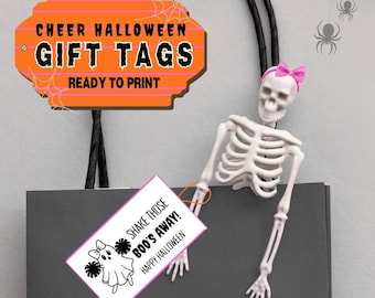 May include: A Halloween-themed gift bag with a skeleton wearing a pink bow. An orange sign reads "CHEER HALLOWEEN GIFT TAGS READY TO PRINT." A gift tag says "SHAKE THOSE BOO'S AWAY! HAPPY HALLOWEEN" with a ghost graphic.