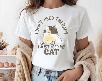 May include: White t-shirt with a brown graphic of a cat and the text "I don't need therapy I just need my cat".