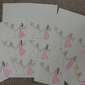 Puede incluir: Una colecci&oacute;n de tarjetas de felicitaci&oacute;n rectangulares blancas con una ilustraci&oacute;n dibujada a mano de dos figuras tomadas de la mano. Una figura viste un vestido blanco y sostiene un ramo, mientras la otra viste un vestido rosa y una copa.