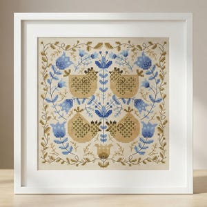 Peut inclure: Une œuvre d'art encadrée carrée avec un motif floral symétrique en beige, bleu et or. L'œuvre est dans un cadre blanc et est exposée sur une surface en bois. Le motif comprend des fleurs et des fruits stylisés.