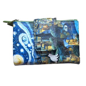 Puede incluir: Una pequeña cartera plegable con un diseño artístico único. La cartera presenta una impresión vibrante inspirada en "La noche estrellada" de Van Gogh y un paisaje urbano. Tiene un cierre a presión y un tirador de cremallera verde.