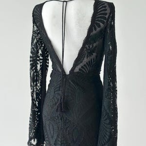 Black lace fringe tassel detail close up, 
dramatic lace texture evening gown fabric