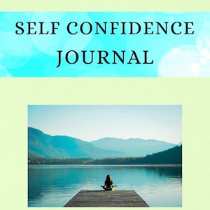 May include: A journal with the words "SELF CONFIDENCE JOURNAL" in black text on a turquoise background. Below, a scenic image of a person meditating on a wooden dock overlooking a lake and mountains.