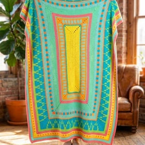 Peut inclure: Une couverture rectangulaire au crochet aux couleurs vives. Le motif comprend un rectangle jaune central, encadré de bordures roses, oranges et turquoise. La couverture est tenue, mettant en valeur ses motifs complexes et sa palette de couleurs vives.