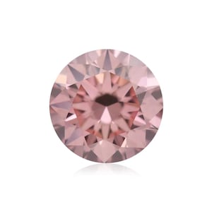 May include: A round, faceted pink diamond. The gemstone has a brilliant cut with numerous facets that reflect light, creating a sparkling effect. The diamond is set against a white background, highlighting its color and clarity.