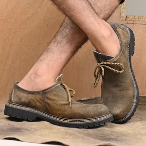 Crossed legs showing Bavarian suede shoes – classic German Oktoberfest footwear