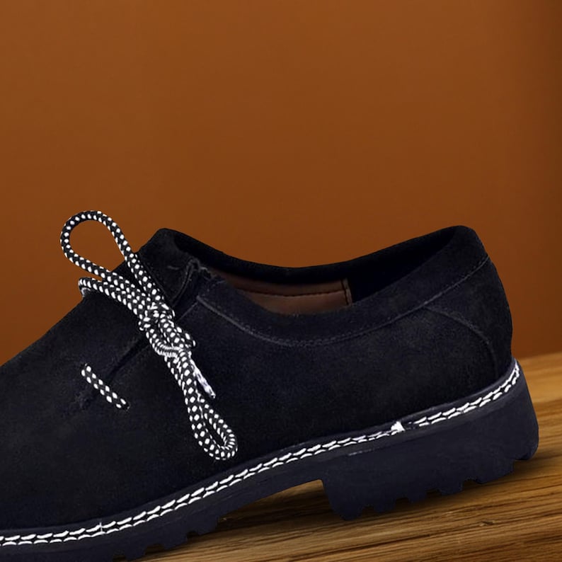 Close-up black oktoberfest shoes with lace detail and stitched suede texture