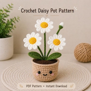 Può includere: Un modello di vaso di margherite all'uncinetto con tre margherite bianche e gialle, foglie verdi e un vaso sorridente. Il testo "Crochet Daisy Pot Pattern" è in alto. Il vaso è marrone e poggia su un tappetino beige.