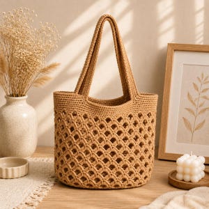 May include: A tan crochet tote bag featuring a diamond-shaped openwork pattern throughout the body, a solid base, and two integrated shoulder straps. The bag is constructed from a single-colored yarn with a consistent, textured stitch design.