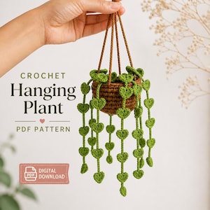 May include: A crocheted hanging plant with a brown pot and green heart-shaped leaves. The plant is suspended by brown cords. The text "CROCHET Hanging Plant PDF PATTERN" is visible.