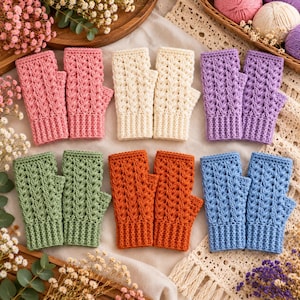 May include: A collection of five pairs of fingerless gloves in various colors including pink, cream, purple, green, orange, and blue. Each pair features a textured crochet pattern with a ribbed cuff and an opening for the thumb.