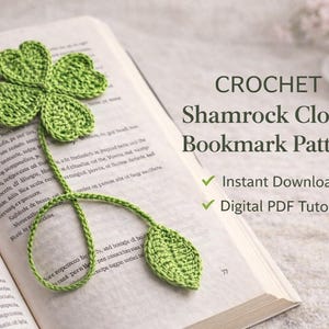 May include: A green crochet shamrock bookmark rests on an open book. The bookmark features a four-leaf clover design with a long stem and two leaves. Text on the page reads "CROCHET Shamrock Clover Bookmark Pattern".