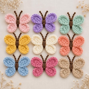 May include: A collection of nine crocheted butterfly appliques arranged in a three-by-three grid. Each butterfly features a dark brown crocheted body with two antennae and wings in various solid colors including pink, purple, mint, yellow, cream, coral, blue, magenta, and beige.
