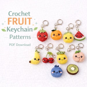 May include: A selection of crochet fruit keyrings, featuring a strawberry, orange, lemon, watermelon, banana, cherries, pineapple, peach, blueberry, and kiwi. Each has a smiling face and a silver keyring. Text reads "Crochet FRUIT Keychain Patterns PDF Download."