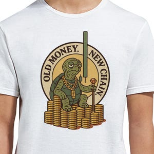May include: White t-shirt with a graphic of a cartoon turtle wearing a gold chain and sitting on a pile of gold coins. The graphic also includes the text "Old Money. New Chain."