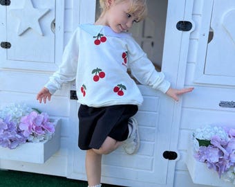 Conjunto infantil para menina com bordado de cerejas, composto por blusa de moletom com gola Peter Pan e shorts. Ideal para a primavera. Lindo conjunto infantil com estampa de cerejas.