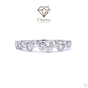 May include: A silver ring with multiple clear, round gemstones set in a bubble design. The ring is set against a white background. The brand logo "Cheriva Jewels" is in the upper center.