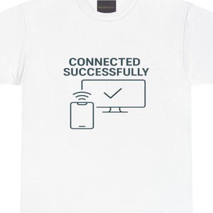 Può includere: Maglietta bianca con una grafica di uno smartphone connesso a uno schermo di computer. Il testo "CONNECTED SUCCESSFULLY" è stampato sopra la grafica.