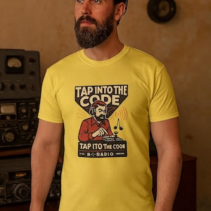 Può includere: T-shirt gialla con grafica vintage che recita "TAP INTO THE CODE" e "R-I RADIO". La grafica presenta un uomo che utilizza una radio. La maglietta è indossata da una persona.