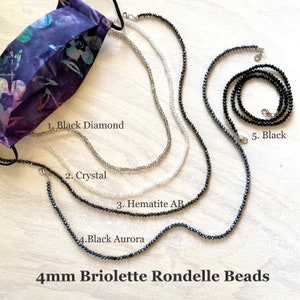 May include: Five different 4mm briolette rondelle bead necklaces in black diamond, crystal, hematite AB, black aurora, and black. The necklaces are displayed on a light wood surface.