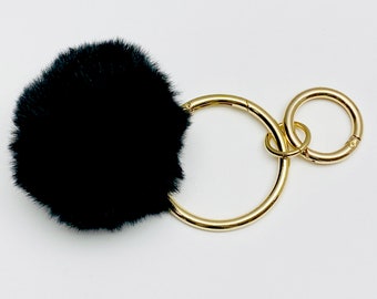 Llavero con pompón de piel sintética negra: un suave abalorio para tu bolso.