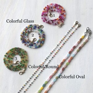 May include: Three different styles of colorful beaded mask chains. The first chain is made of colorful glass beads, the second is made of colorful round beads, and the third is made of colorful oval beads. Each chain has a gold clasp on each end.