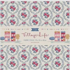 Peut inclure: Un assortiment de tissus Tilda Village Life comprenant 40 pièces de 25,4 x 25,4 cm. L'emballage présente un fond beige avec un motif floral répétitif de roses roses et de feuilles bleues, ainsi qu'une illustration centrale de maisons colorées.