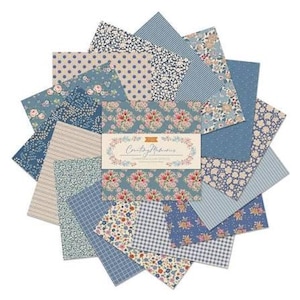 Puede incluir: Una pila de muestras de tela cuadradas dispuestas en forma de estrella, con varios estampados florales, de lunares, rayas y cuadros en tonos azul, crema y rosa. Una banda central de papel muestra el texto "Counting Memories" en letra cursiva.
