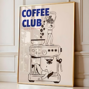 Könnte beinhalten: Gerahmter Kunstdruck mit goldenem Rahmen, der eine Illustration zum Thema Kaffee zeigt. Das Bild zeigt eine Person, die Kaffeebohnen in eine Kaffeemaschine gießt, mit den Worten "COFFEE CLUB" in Blau und "every morning" in Rot.
