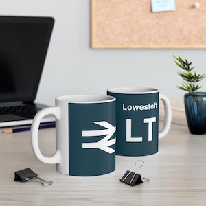 Peut inclure: Deux tasses en céramique blanche avec un motif bleu foncé. Une tasse porte le texte "Lowestoft LT" et l'autre un symbole ferroviaire blanc.
