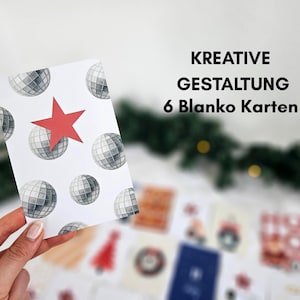 May include: A white card with a pattern of disco balls and a red star is held in front of other cards. The text "KREATIVE GESTALTUNG 6 Blanko Karten" is displayed in black. The cards are likely for a holiday or special occasion.