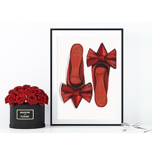 Op de afbeelding: Een ingelijste aquarelprint met twee paar rode ballerina's met strikken. De schoenen staan op een witte achtergrond. Een zwarte doos met rode rozen en een label staan op de voorgrond.