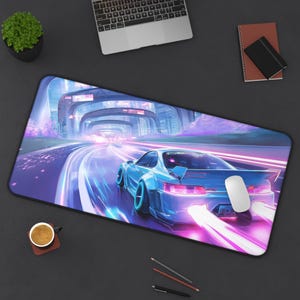 May include: A large rectangular mouse mat with a futuristic design of a blue sports car racing on a neon-lit track. The design features vibrant purple and blue colours, with a blurred background suggesting speed. A white mouse is on the mat.