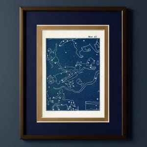 Könnte beinhalten: Gerahmter Vintage-Druck einer Himmelskarte mit weißen Sternbildern und Figuren auf tiefblauem Hintergrund. Der Druck ist doppelt mattiert und in einem dunkelbraunen Rahmen mit goldfarbenem Innenrand gerahmt. Der Text "Map 27" ist sichtbar.