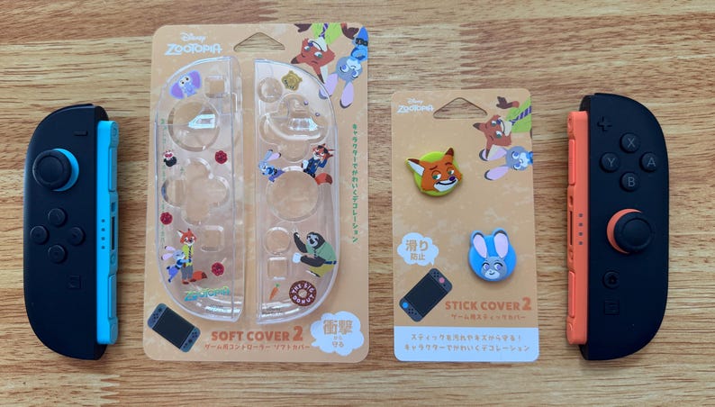 以下が含まれることがあります： ディズニー映画「ズートピア」をテーマにしたNintendo Switchアクセサリーのセット。 青とオレンジのアクセントが付いた2つの黒いコントローラー、キャラクターグラフィック付きの透明保護カバー、スティックカバーが含まれています。