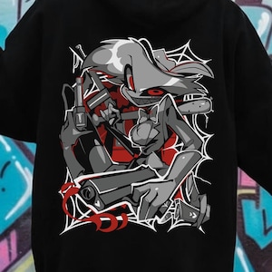 May include: Black hoodie featuring a detailed graphic of a cartoon character with a gun, in shades of gray and red. The design is set against a white web-like background. The hoodie is a casual wear item.